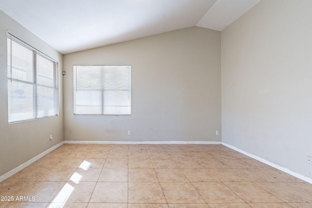 unfurnished room featuring lofted ceiling, light tile patterned floors, and baseboards