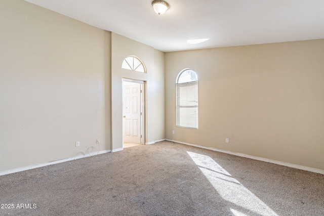 carpeted empty room with baseboards