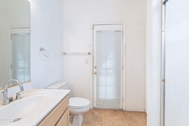 bathroom with vanity, toilet, and tile patterned floors