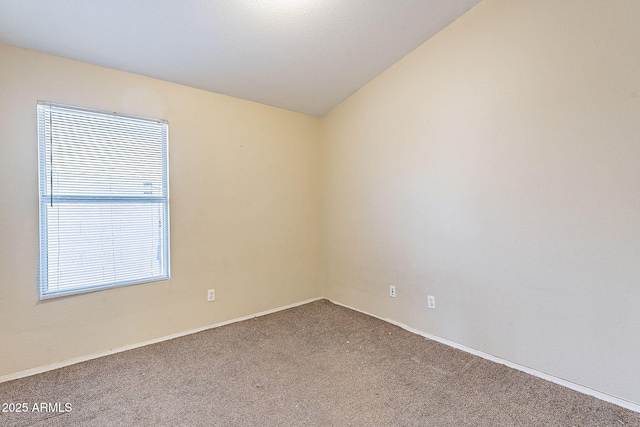 carpeted empty room featuring lofted ceiling