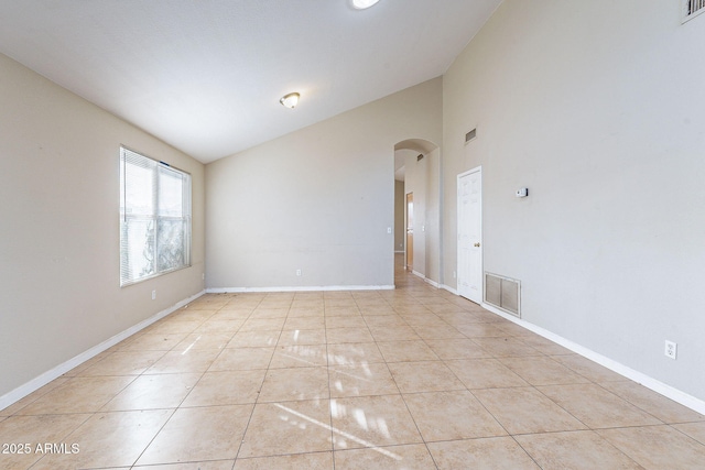 spare room featuring arched walkways, visible vents, and baseboards