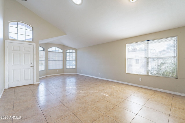 foyer with light tile patterned floors, lofted ceiling, and baseboards