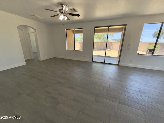 7116 W Sophie Ln, Laveen, AZ 85339 - unfurnished room featuring arched walkways, a ceiling fan, and baseboards