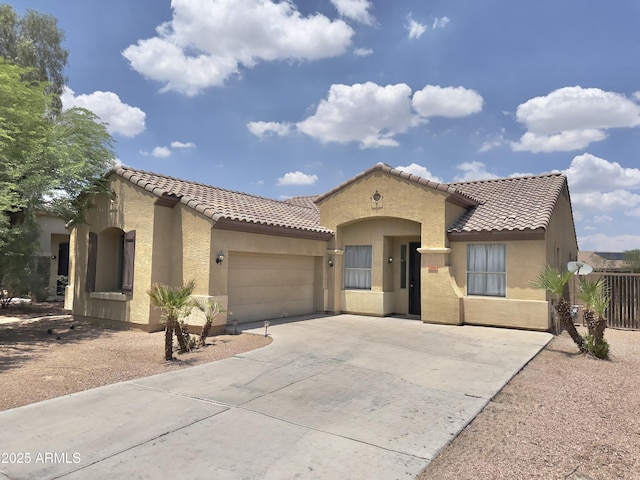 7116 W Sophie Ln, Laveen, AZ 85339 - mediterranean / spanish-style home featuring driveway, stucco siding, a tiled roof, and a garage