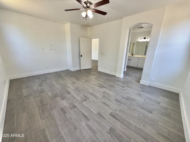 7116 W Sophie Ln, Laveen, AZ 85339 - unfurnished bedroom with arched walkways, wood finished floors, and baseboards