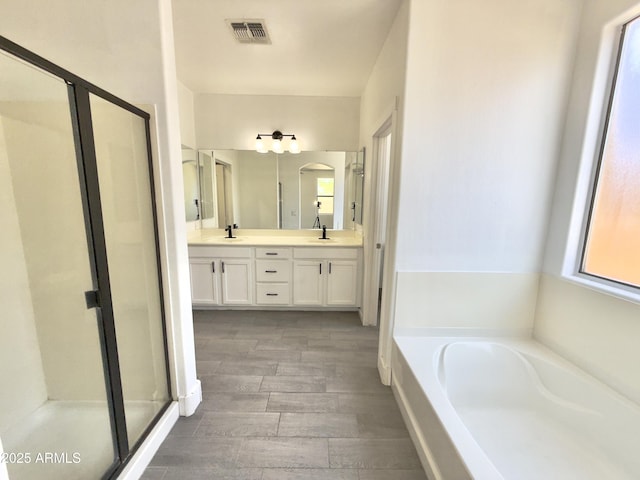 7116 W Sophie Ln, Laveen, AZ 85339 - full bath featuring a shower stall, a garden tub, double vanity, and wood finished floors