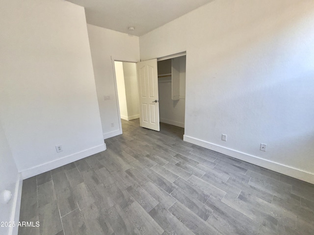 7116 W Sophie Ln, Laveen, AZ 85339 - unfurnished bedroom featuring wood finished floors, baseboards, and a closet