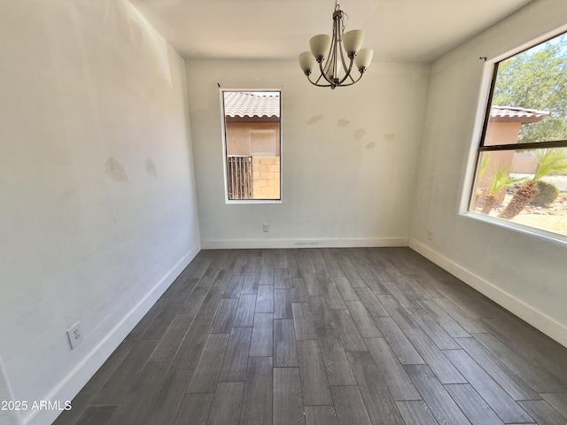 7116 W Sophie Ln, Laveen, AZ 85339 - empty room featuring a chandelier, dark wood finished floors, and baseboards
