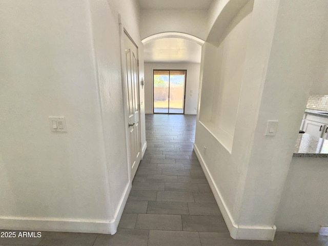 7116 W Sophie Ln, Laveen, AZ 85339 - hallway featuring arched walkways, baseboards, and dark tile patterned flooring