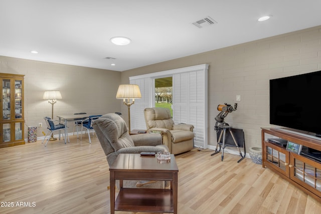 living room featuring light wood-type flooring, visible vents, and recessed lighting