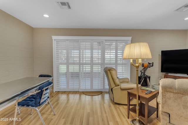 living area featuring recessed lighting, visible vents, and wood finished floors