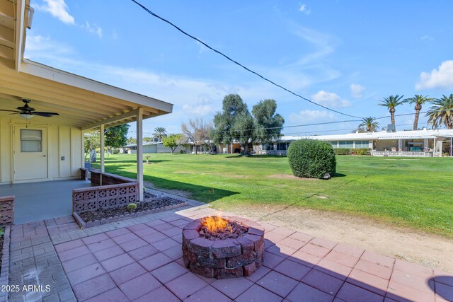 view of patio with an outdoor fire pit and a ceiling fan