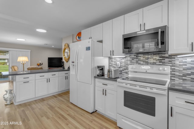 kitchen with tasteful backsplash, white appliances, dark countertops, and white cabinets