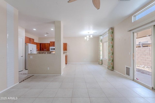 interior space featuring visible vents, light tile patterned floors, baseboards, ceiling fan with notable chandelier, and recessed lighting