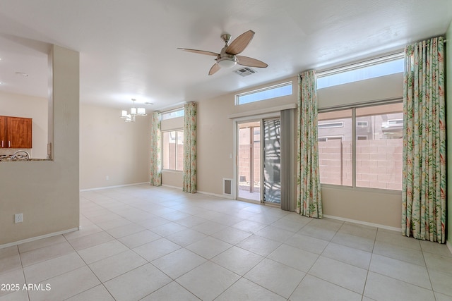 unfurnished room featuring baseboards, ceiling fan with notable chandelier, light tile patterned flooring, and visible vents