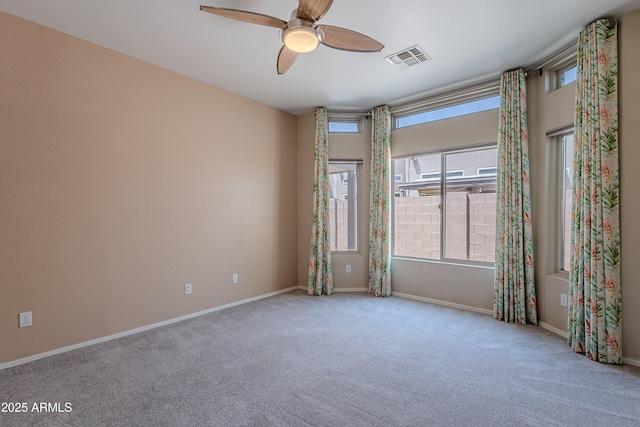 carpeted spare room featuring a ceiling fan, baseboards, and visible vents