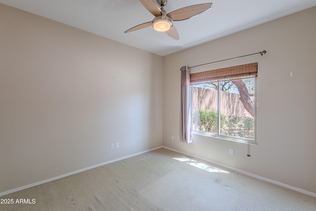 empty room featuring baseboards, light colored carpet, and ceiling fan
