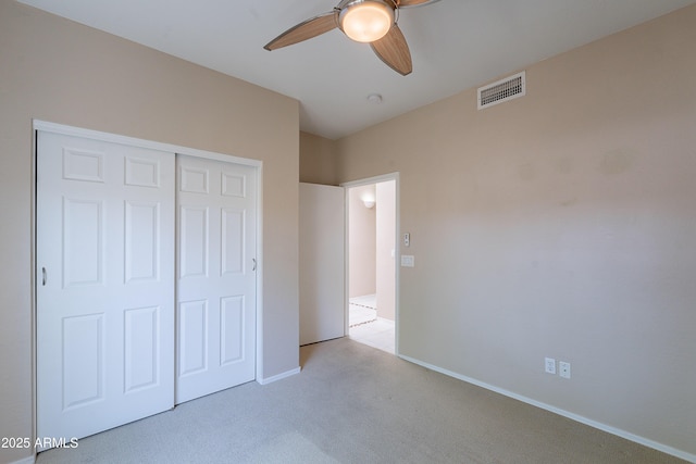 unfurnished bedroom with visible vents, a closet, baseboards, ceiling fan, and carpet