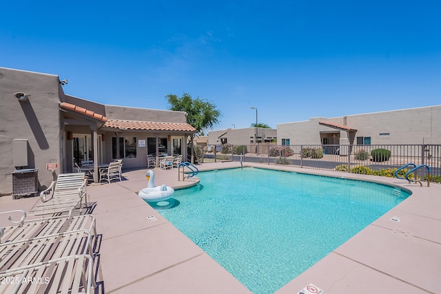 community pool featuring fence and a patio area