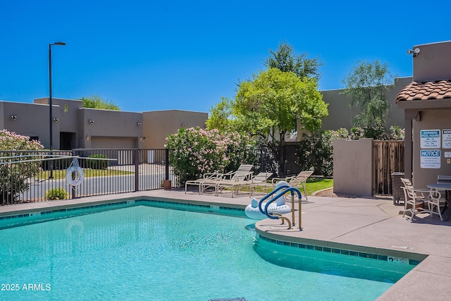 community pool featuring a patio area and fence