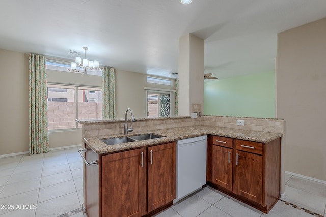 kitchen featuring light stone counters, a sink, dishwasher, and light tile patterned flooring