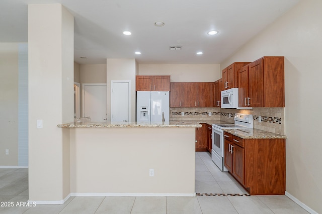 kitchen featuring light stone counters, white appliances, a peninsula, tasteful backsplash, and visible vents
