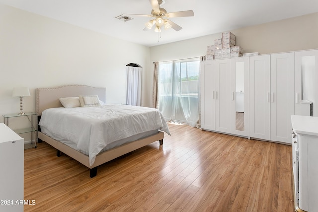 bedroom featuring access to outside, a ceiling fan, visible vents, and light wood-style floors