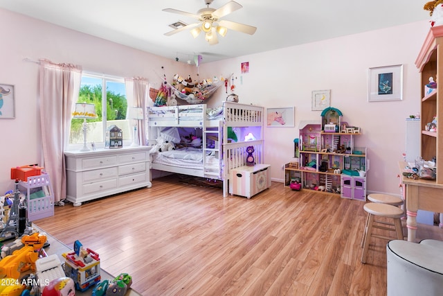 bedroom with light wood finished floors, visible vents, and a ceiling fan