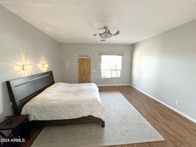 bedroom with baseboards and wood finished floors