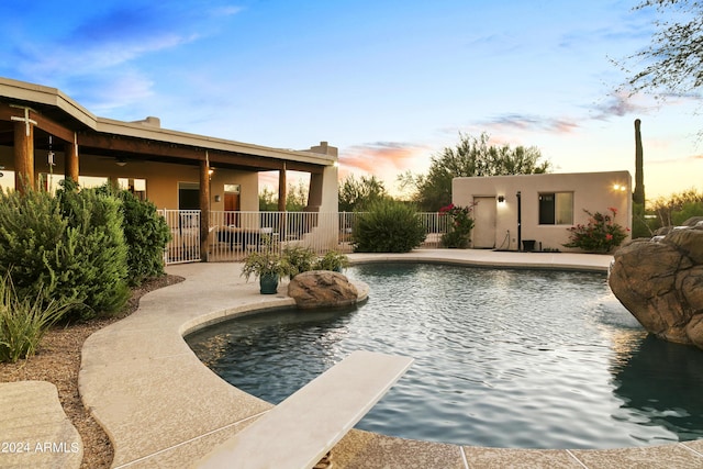 view of swimming pool featuring a patio area, fence, a diving board, and a fenced in pool