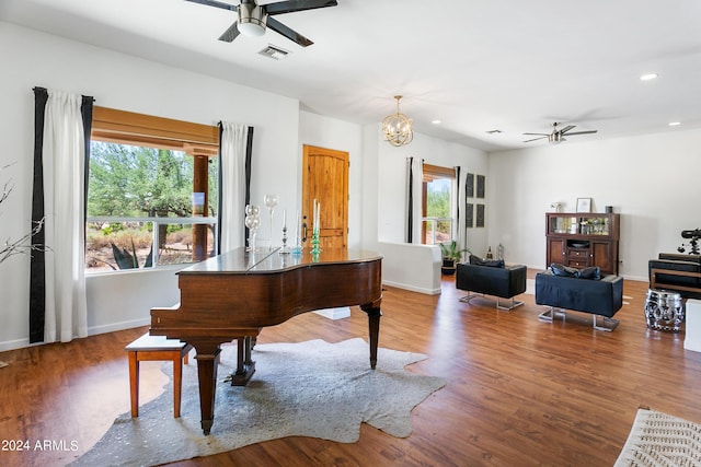 sitting room with recessed lighting, visible vents, wood finished floors, baseboards, and ceiling fan with notable chandelier