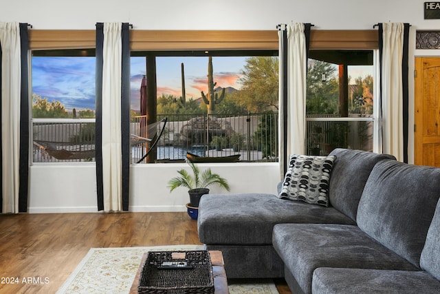 living area with baseboards and wood finished floors