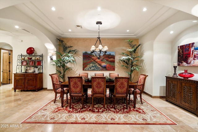 dining area with ornamental molding and a chandelier