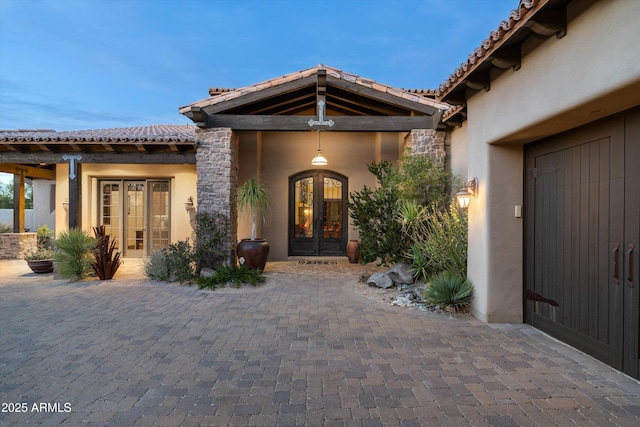 view of exterior entry with a patio area and french doors