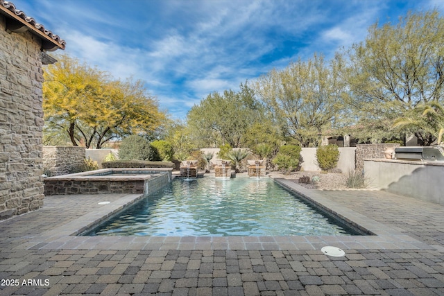 view of swimming pool featuring a grill, an outdoor kitchen, a patio, and an in ground hot tub