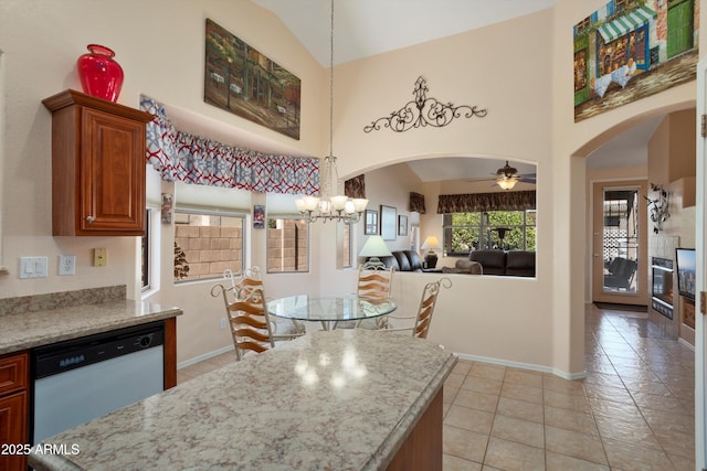 kitchen featuring arched walkways, high vaulted ceiling, white dishwasher, baseboards, and hanging light fixtures