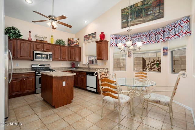 kitchen featuring appliances with stainless steel finishes, a kitchen island, a sink, high vaulted ceiling, and ceiling fan with notable chandelier