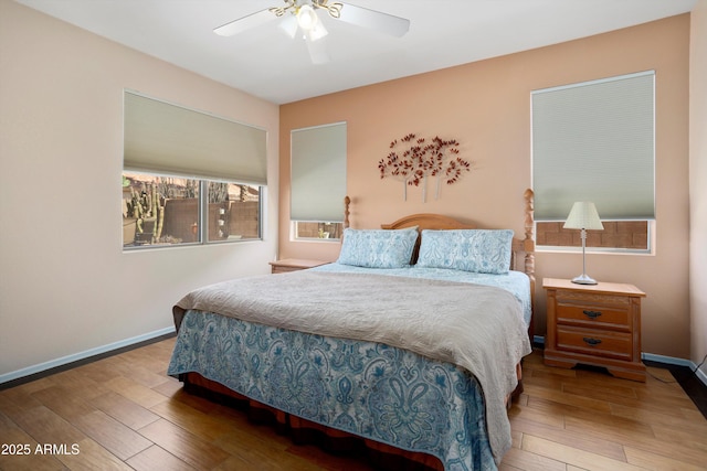 bedroom featuring ceiling fan, baseboards, and wood finished floors