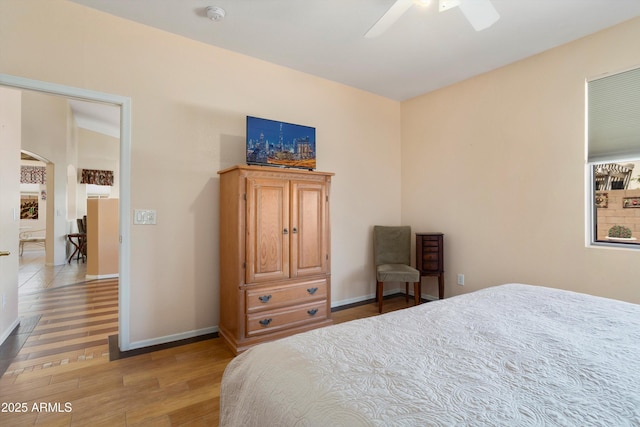 bedroom featuring ceiling fan, light wood finished floors, and baseboards