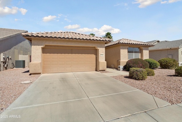 mediterranean / spanish-style house with central AC unit, concrete driveway, a tiled roof, an attached garage, and stucco siding