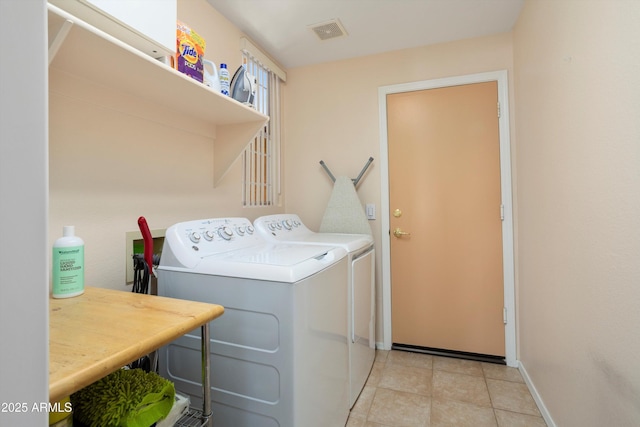 clothes washing area with light tile patterned flooring, laundry area, visible vents, baseboards, and washer and dryer