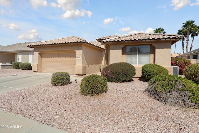 view of front of property with a tile roof, driveway, an attached garage, and stucco siding