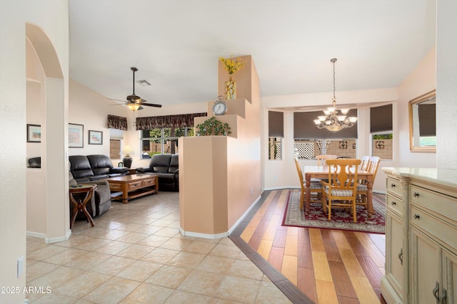 dining area with ceiling fan with notable chandelier, visible vents, light wood-style flooring, and baseboards