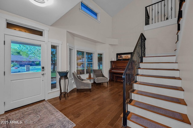 entryway featuring high vaulted ceiling, stairs, and wood finished floors