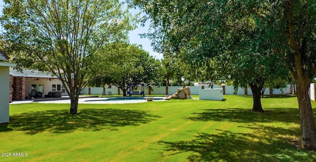 view of community featuring a lawn and fence