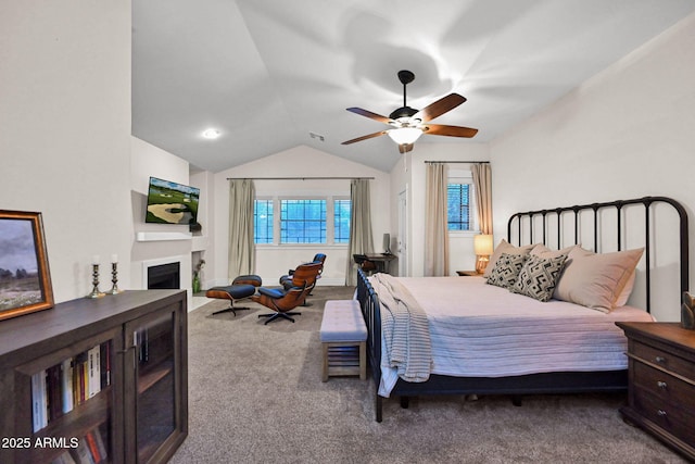 bedroom featuring ceiling fan, a fireplace, carpet, and vaulted ceiling