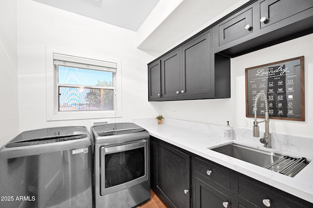 washroom featuring a sink, cabinet space, light wood-type flooring, and separate washer and dryer