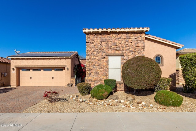 view of front facade with a garage and solar panels