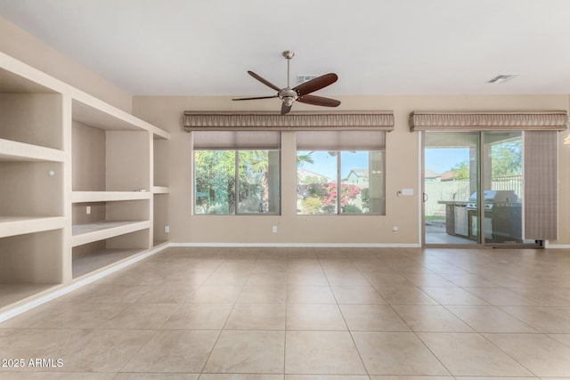 tiled spare room with built in features, ceiling fan, and a healthy amount of sunlight