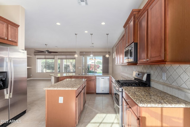 kitchen featuring kitchen peninsula, decorative backsplash, a center island, and appliances with stainless steel finishes